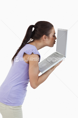 Young female kissing laptop screen