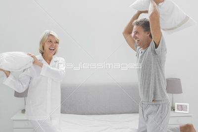 Cheerful couple sitting on bed