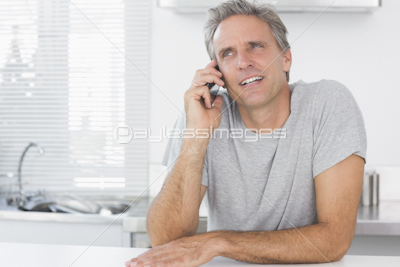 Cheerful man using tablet pc in kitchen