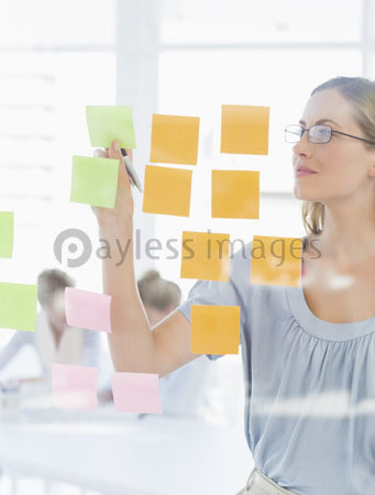 Concentrated artist is looking at the variegated sticky note.