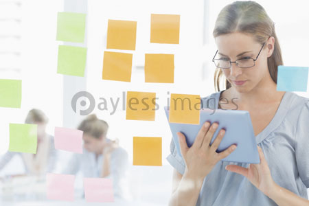 Concentrated artist with a digital tablet and a variegated sticky note