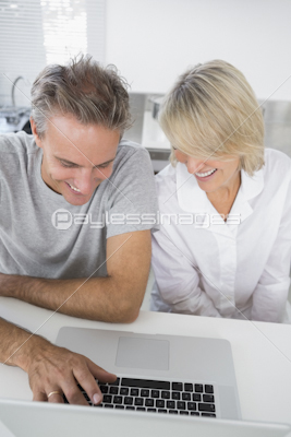 Content couple using laptop in the morning