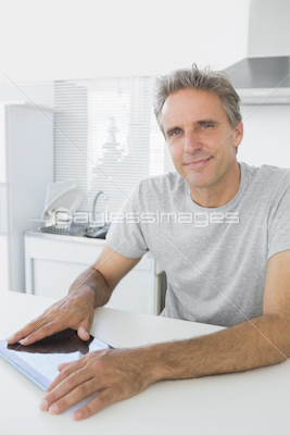 Happy man using laptop in kitchen