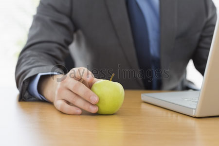 It is dressed businessman to skill with office laptop and an apple.