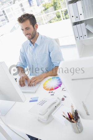It smiles and expresses the computer which a male photo editor uses.