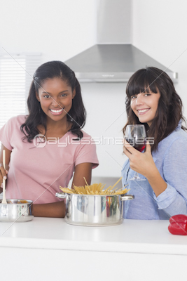 Laughing friends preparing a salad together