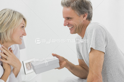 Man giving present to his surprised partner