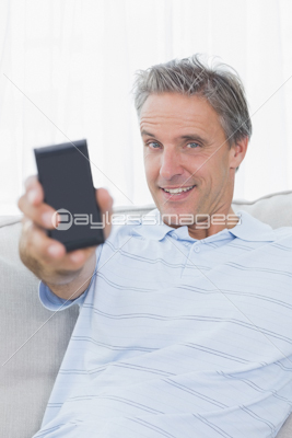 Man relaxing on his couch sending a text