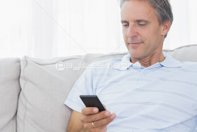 Man relaxing on his sofa with a book 