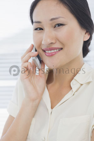 The beautiful female businessman is using the mobile phone.