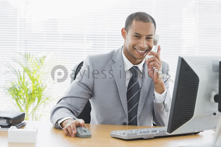 The computer and telephone which the businessman of an office desk uses