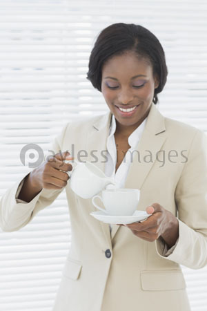 The decent female businessman with the tea cup of the office who smiles