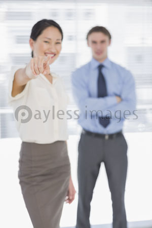 The female businessman points out office people and a camera.