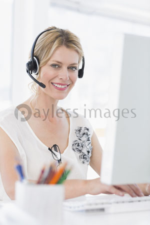The portrait of an accidental woman with the computer which a headset uses
