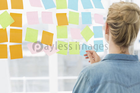 The rear elevation of the artist of the woman who looks at a variegated sticky note