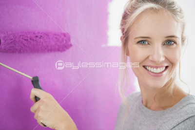 Woman painting her wall pink