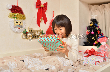 クリスマスプレゼントをもらって喜ぶ女の子 寝室 商用利用可能な写真素材 イラスト素材ならストックフォトの定額制ペイレスイメージズ