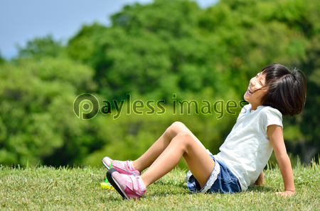 芝生広場で笑う女の子 商用利用可能な写真素材 イラスト素材ならストックフォトの定額制ペイレスイメージズ