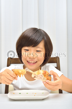フライドチキンを美味しそうに食べる女の子 商用利用可能な写真素材 イラスト素材ならストックフォトの定額制ペイレスイメージズ