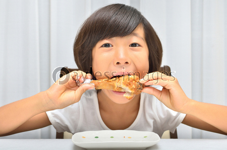 フライドチキンを美味しそうに食べる女の子 商用利用可能な写真素材 イラスト素材ならストックフォトの定額制ペイレスイメージズ