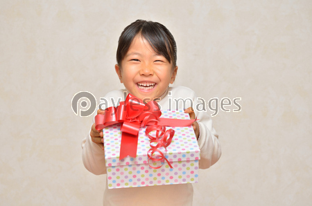 プレゼントを差し出す女の子 商用利用可能な写真素材 イラスト素材ならストックフォトの定額制ペイレスイメージズ