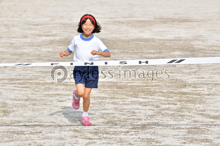 走る女の子 体操服 ゴールテープ ストックフォトの定額制ペイレスイメージズ