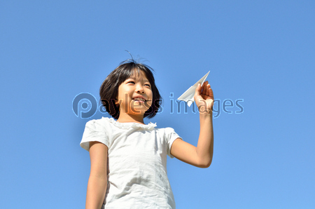 青空に紙飛行機を飛ばす女の子 ストックフォトの定額制ペイレスイメージズ