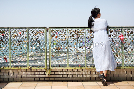 フェンスに寄りかかる女性 ストックフォトの定額制ペイレスイメージズ