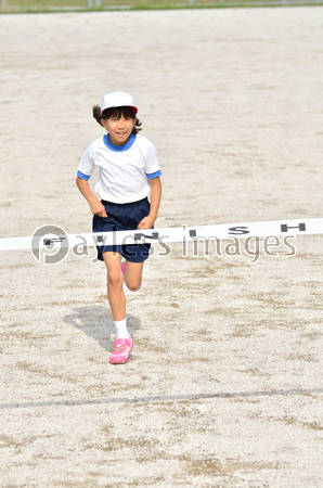 走る女の子 体操服 ゴールテープ ストックフォトの定額制ペイレスイメージズ
