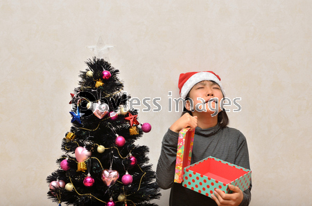プレゼントを開ける女の子 クリスマスツリー ストックフォトの定額制ペイレスイメージズ