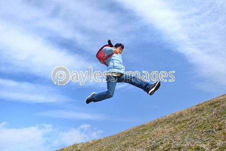 青空でジャンプする女の子 ランドセル ストックフォトの定額制ペイレスイメージズ