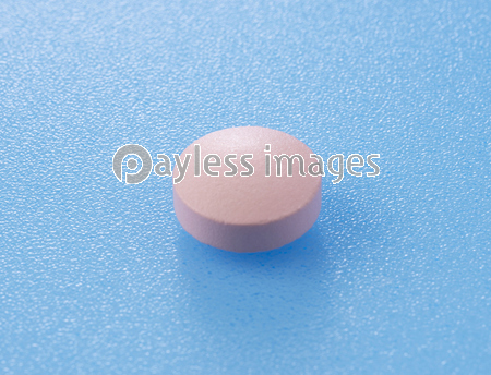 青い背景に置かれたピンクの錠剤 ストックフォトの定額制ペイレスイメージズ