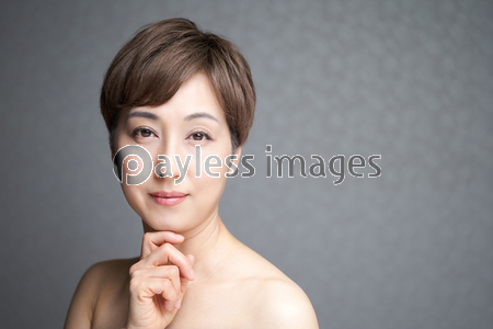カメラ目線で顎に手を当てる中年の日本人女性 ストックフォトの定額制ペイレスイメージズ