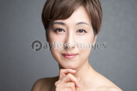 顎に手を当てる目をつぶる中年の日本人女性 ストックフォトの定額制ペイレスイメージズ