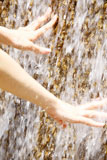 流れる水に突っ込まれた女性の手