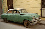 A+building+structure+with+an+antique+car+parked+in+front%2C+Havana%2C+Cuba