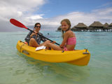 A+young+woman+sitting+in+a+boat+with+a+young+girl+%2812-13%29%2C+Moorea%2C+Tahiti%2C+French+Polynesia%2C+South+Pacific