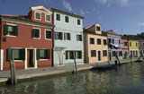 An+array+of+colorful+residential+buildings+along+a+canal+in+Venice%2C+Burano%2C+Italy