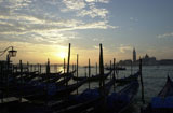 Silhouettes+of+gondolas+docked+during+a+sunset+at+a+canal+in+Venice%2C+Italy
