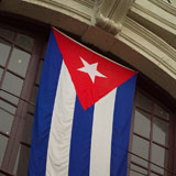 Low+angle+view+of+a+flag+hanging+in+front+of+a+building%2C+Havana%2C+Cuba