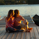 Mother+and+daughter+sitting+on+dock+at+sunset