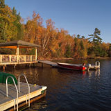 Boat+at+dock+with+forest+in+autumn+colours