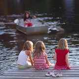 Three+girls+sitting+on+a+dock+with+their+feet+in+the+water