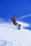 Snowboarder+coming+down+snowy+hill+smiling