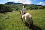 Woman+outdoors+riding+horse+in+scenic+location