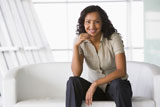 Businesswoman+sitting+indoors+smiling+%28high+key%2Fselective+focus%29