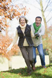 Senior+couple+outdoors+running+around+and+smiling+%28selective+focus%29