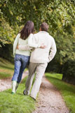 Couple+walking+outdoors+on+path+in+park+%28selective+focus%29