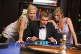 Three+people+in+casino+playing+roulette+smiling+%28selective+focus%29