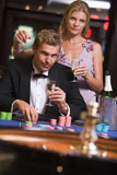 Couple+in+casino+playing+roulette+and+smiling+%28selective+focus%29